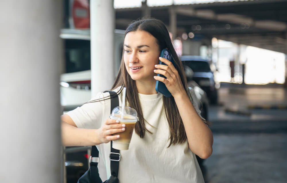 Una persona hablando con su smartphone en una estación de tren